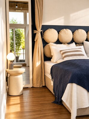 Ein Schlafzimmer mit Bett, Nachttisch, Lampe und Vorhängen.