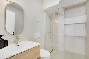A modern bathroom with a white sink, mirror, and shower. - Cozy Studio (Paris)