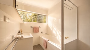 A modern bathroom with a shower, a bathtub, and a window. - Zen Retreat: Cinema, Pet-Friendly Yard (Springwood)
