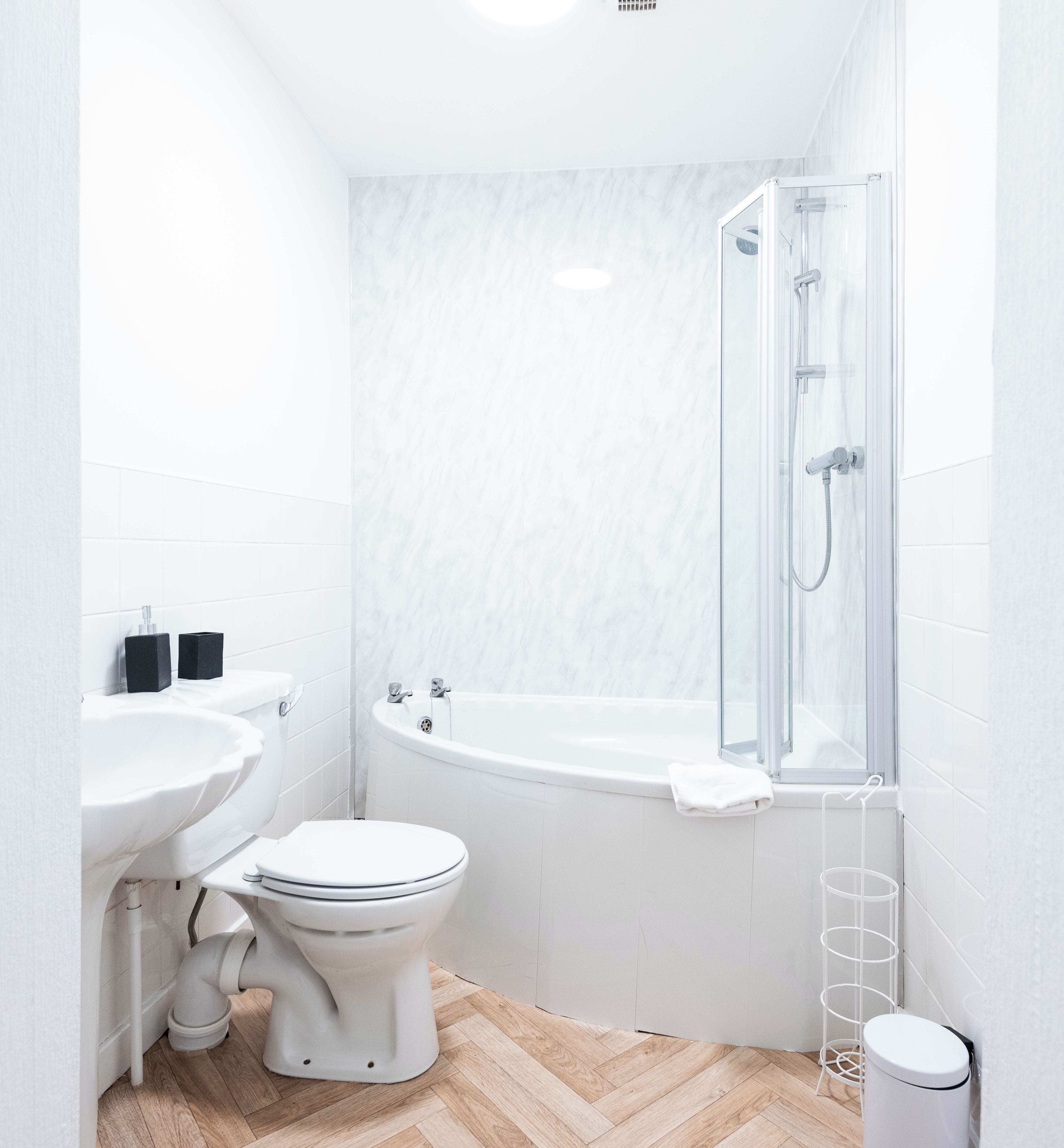 A modern bathroom with a toilet, sink, and glass-enclosed shower.