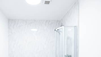 A modern bathroom with a freestanding bathtub, a toilet, and a shower enclosure.