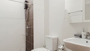 Een badkamer met toilet, wastafel en douche.
