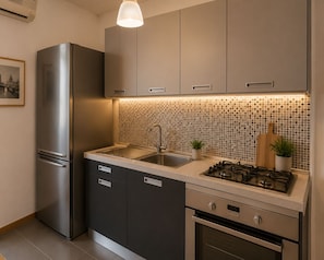 A modern kitchen with a stainless steel refrigerator, a gas stove, and a sink. - 15 minutes to Colosseum! Family apartment for 6 person (Roma)