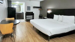 Ein Hotelzimmer mit Bett, Schreibtisch, Stuhl, Kleiderschrank und Spiegel.