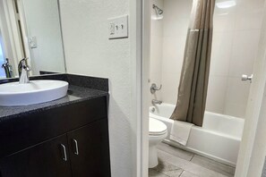 Ein Badezimmer mit einem weißen Waschbecken, einer Toilette und einer Badewanne.