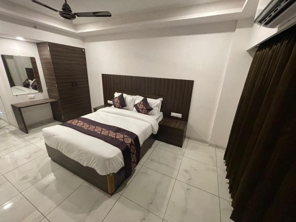 Ein modernes Schlafzimmer mit einem Bett, Nachttischen, einem Spiegel und einem Deckenventilator.