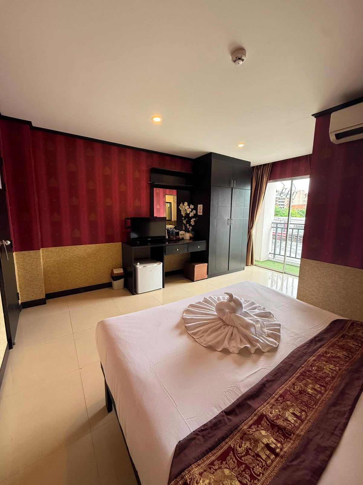 Une chambre d’hôtel avec un lit, un bureau, une armoire et une vue sur l’extérieur.