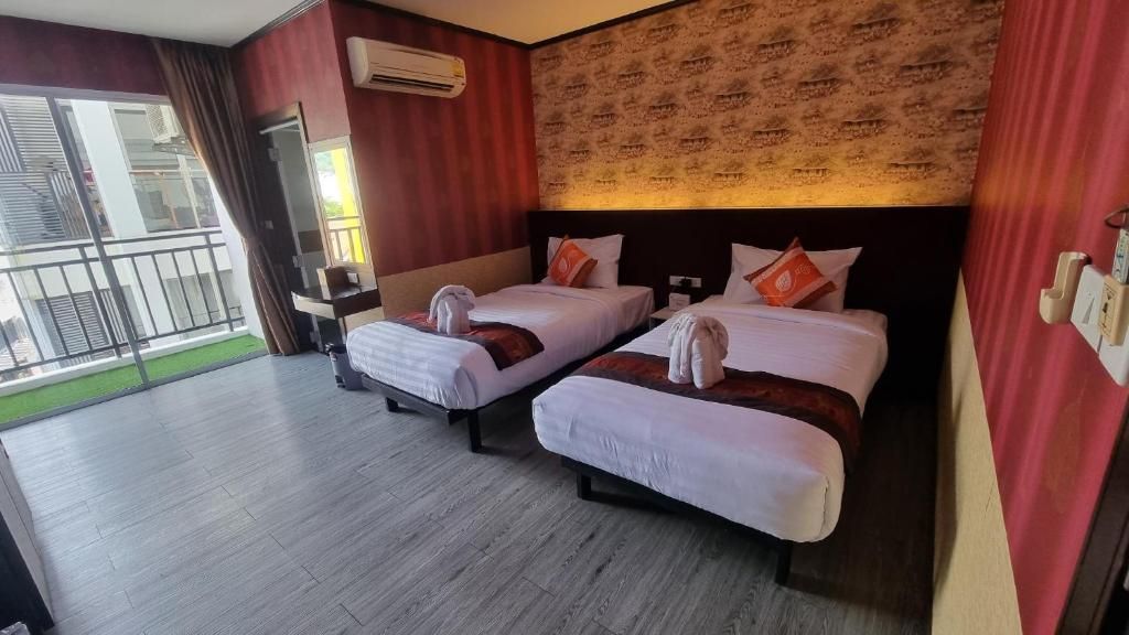 Una habitación de hotel con dos camas, un escritorio pequeño y un balcón.