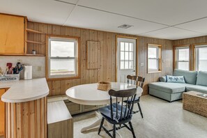 Un espacio habitable compacto con cocina, mesa de comedor y zona de estar.