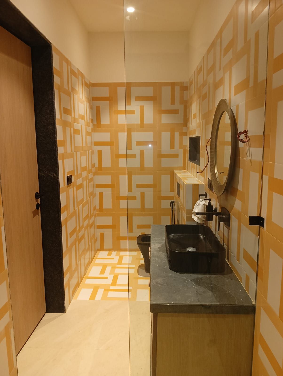 Un baño con paredes decoradas, un lavabo, un espejo y un inodoro.