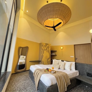 Een hotelkamer met een bed, een bijzondere spiegel, een kledingkast en een plafondventilator.