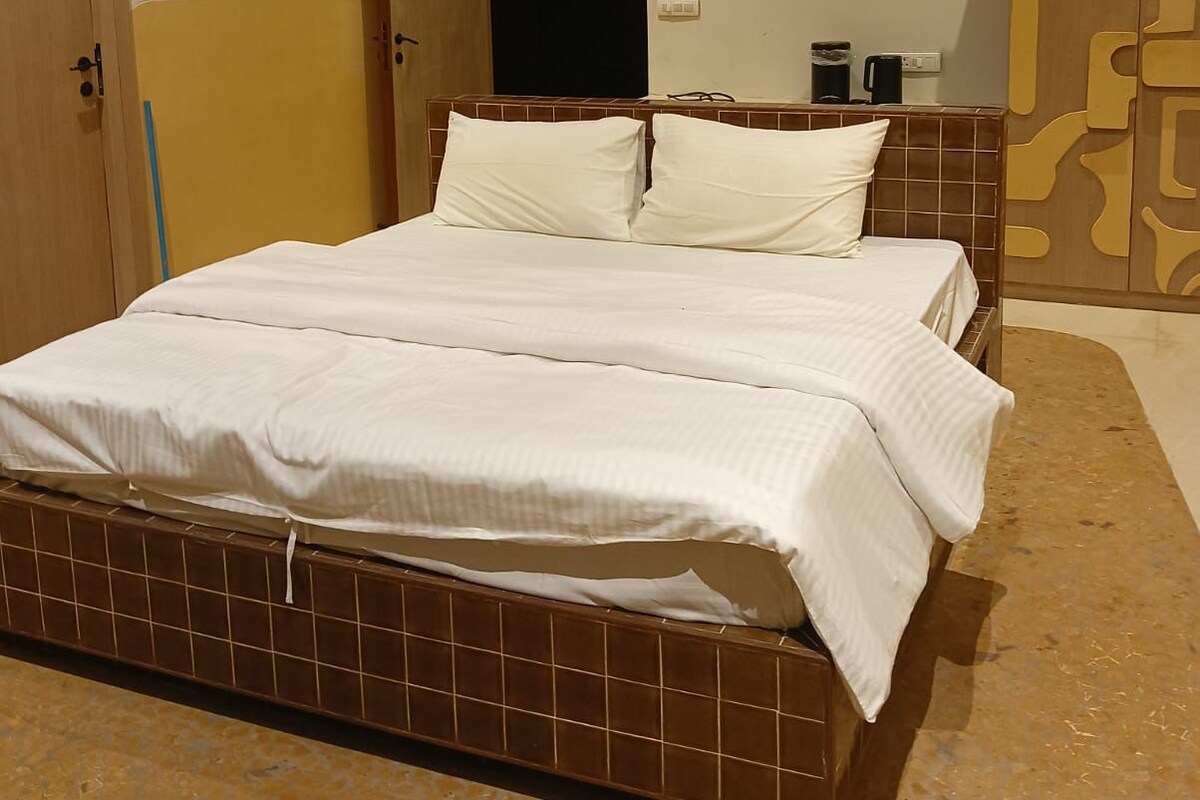 Een slaapkamer met een bed, een kledingkast en een badkamers deur.