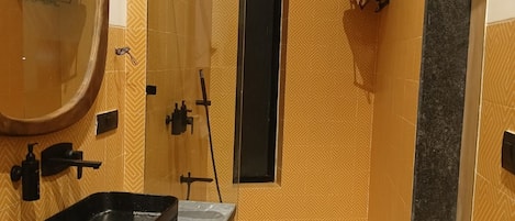 Un baño con tocador, espejo, toallero y zona de ducha.