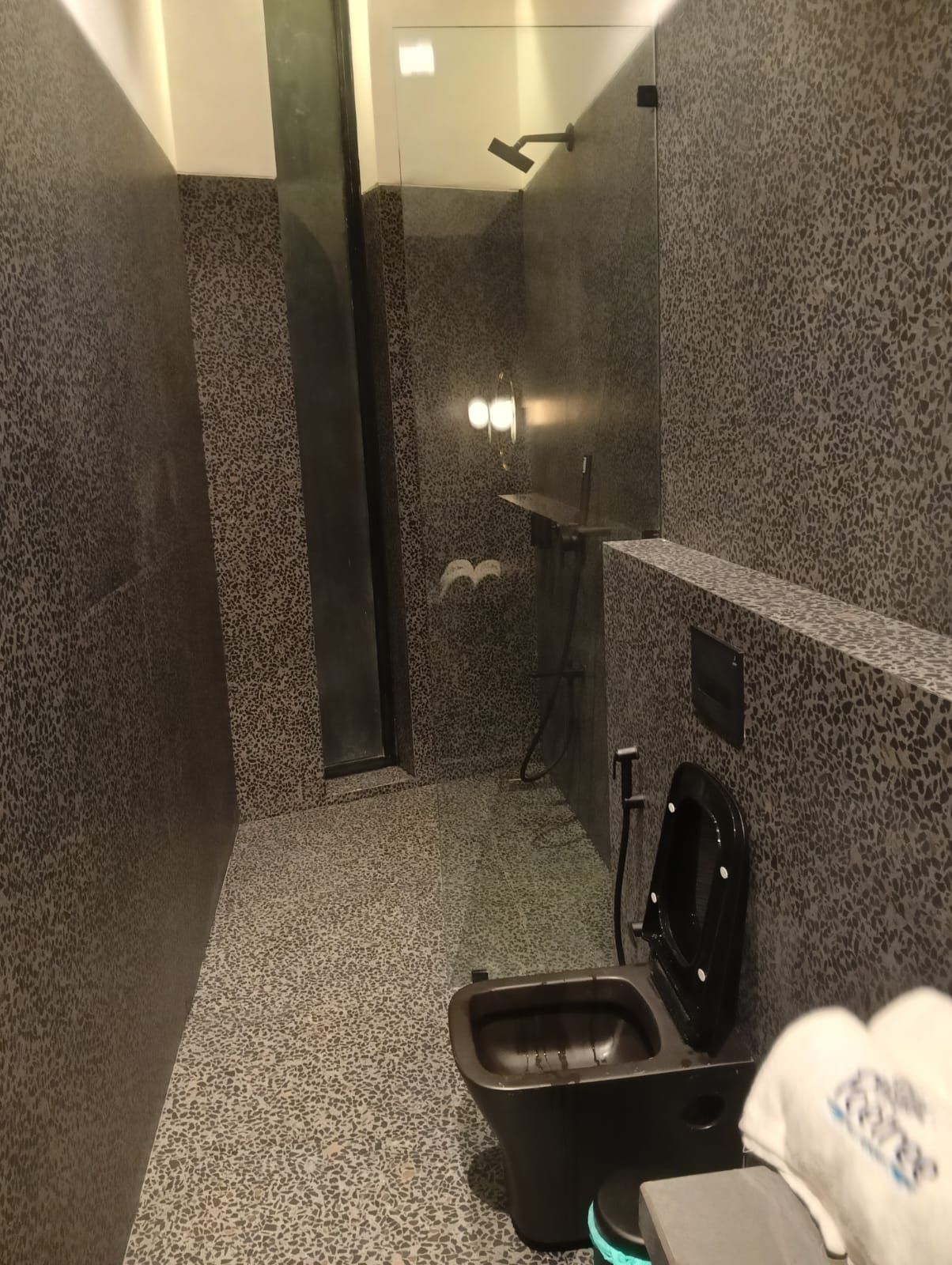 Un baño pequeño y privado con ducha, inodoro y lavamanos.