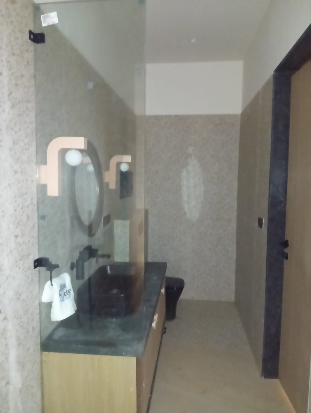 A bathroom with a mirror, sink, and towel rack.