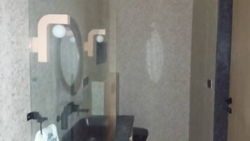 A bathroom with a mirror, sink, and towel rack.
