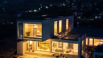 Una casa moderna con piscina, ventanas amplias y vista a la montaña.