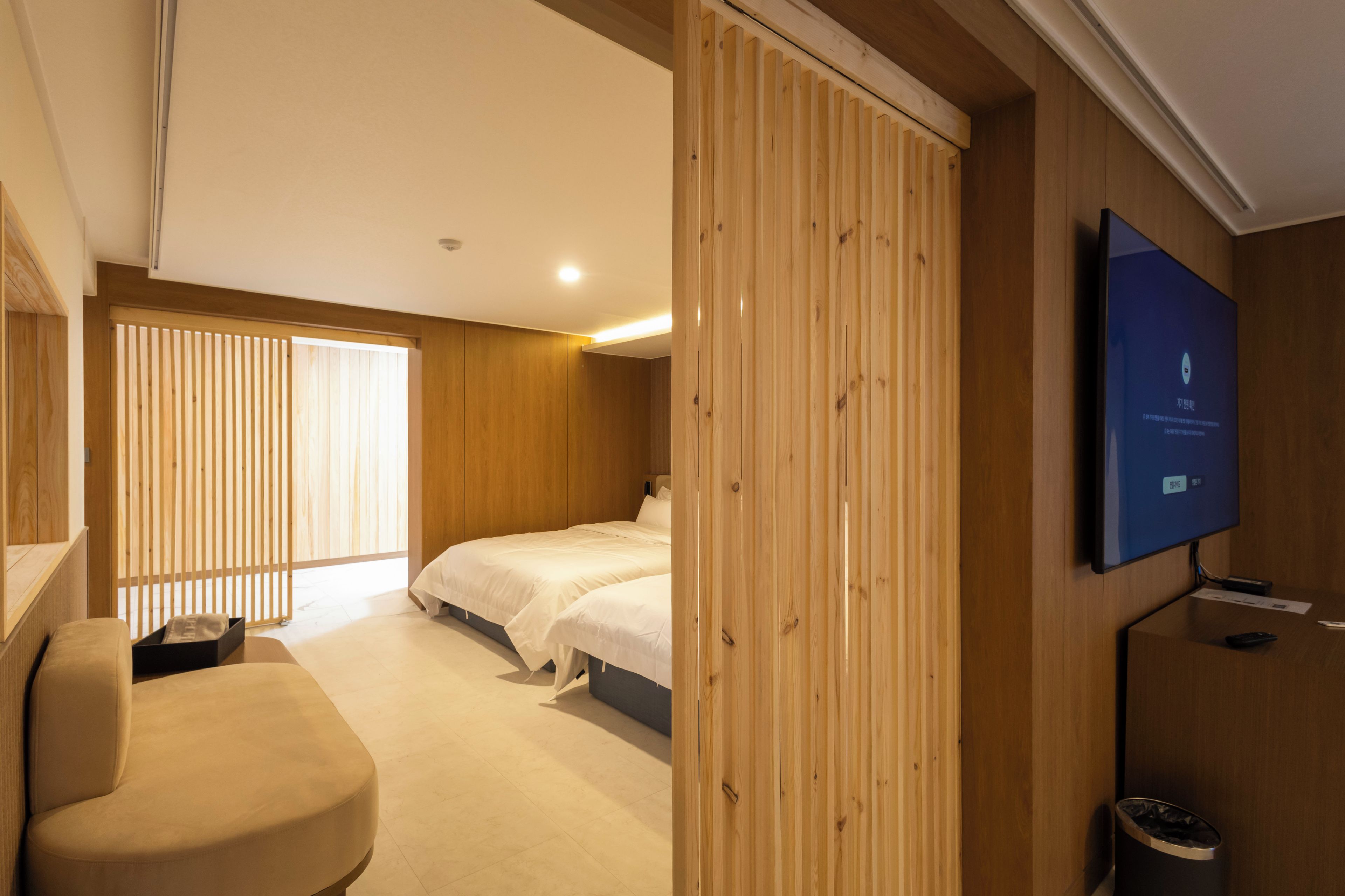 Habitación de hotel con dos camas, televisión, escritorio y silla.
