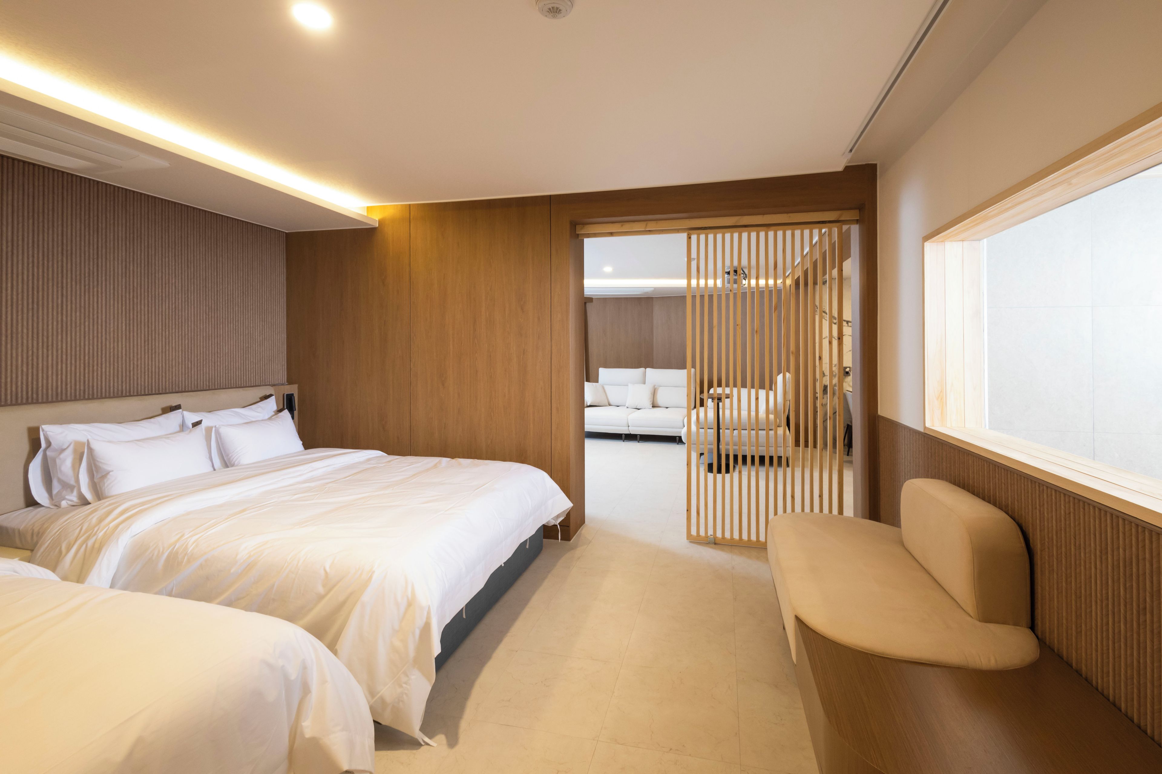 Habitación de hotel con cama, sofá y vista a través de una puerta.