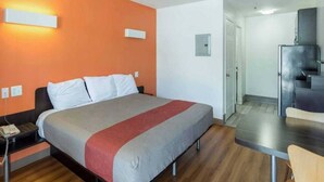 Una habitación de hotel con una cama, un escritorio y una silla.