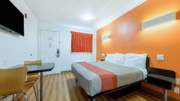 Une chambre d’hôtel avec un lit, un bureau et une chaise.