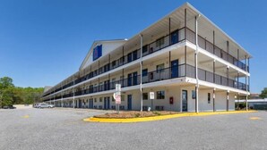 Un motel de varios pisos con techo plano y balcones en cada planta.
