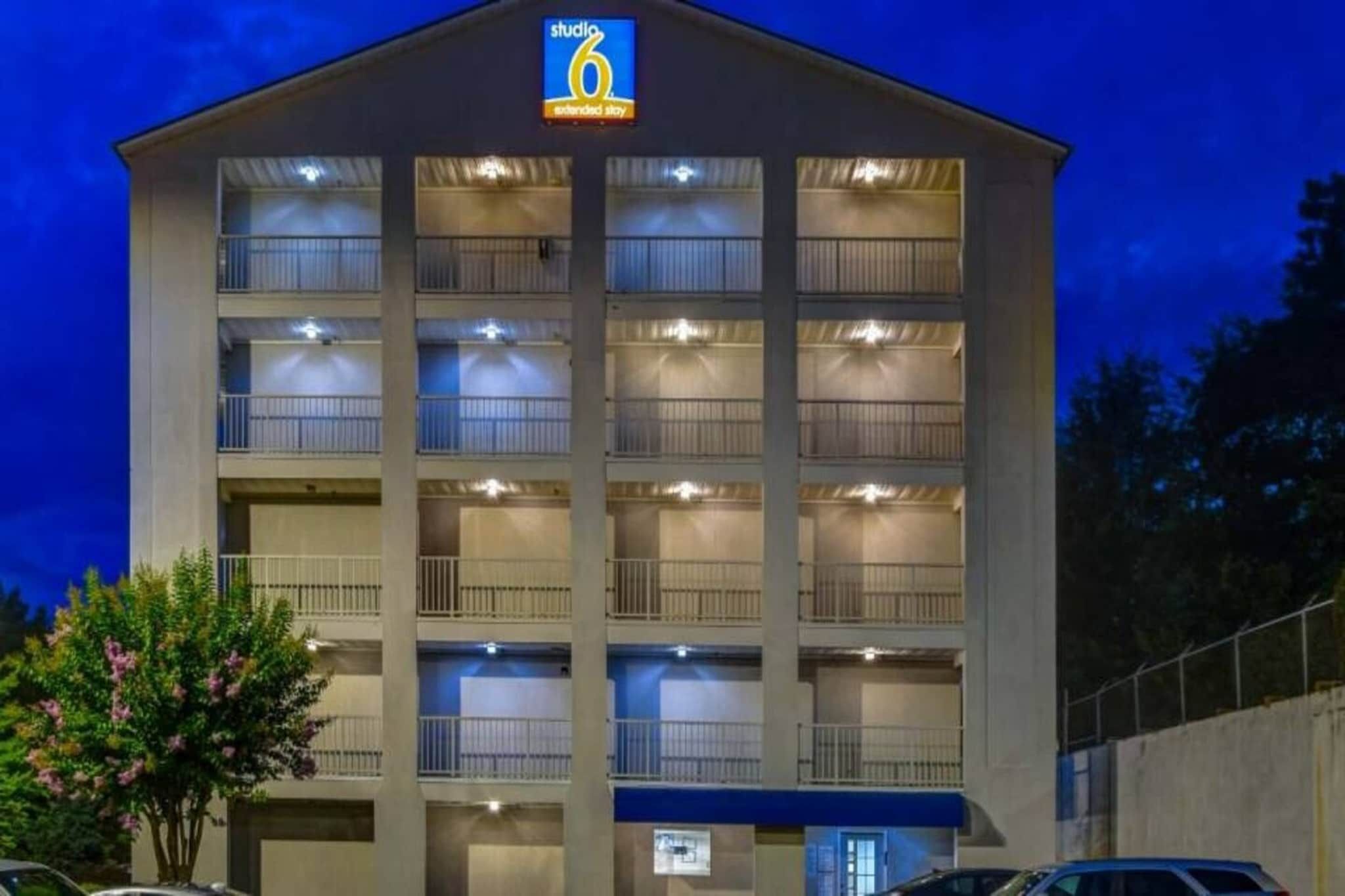 Ein mehrgeschossiges Hotel mit einem Schild, das angibt, dass es sich um ein Studio 6 Hotel für längeren Aufenthalt handelt.