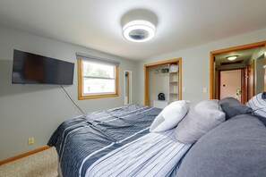 A bedroom with a bed, a television, a window, and a closet. - Kenosha Mid-Term Rental w/ Fenced Yard (Kenosha)