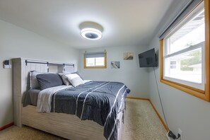 A bedroom with a bed, a ceiling light, a window, and a wall-mounted TV. - Kenosha Mid-Term Rental w/ Fenced Yard (Kenosha)