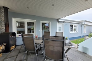 An outdoor patio with a grill, chairs, and a table. - Apartment 'Ferienwohnung Zeitlos' (Stralsund)
