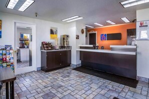 A reception area with a counter, a coffee machine, and a sign indicating 'Employees Only'.