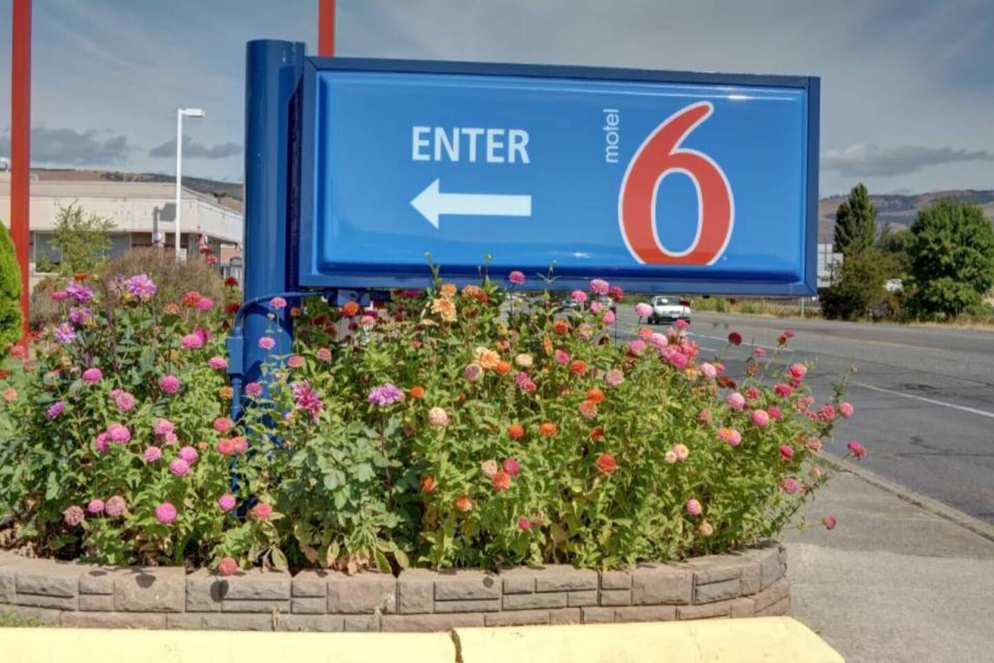 Une enseigne de motel avec une flèche pointant vers la gauche, indiquant la direction à suivre pour entrer.