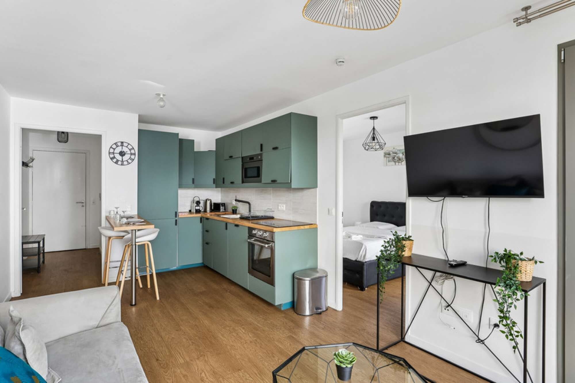 A modern kitchen with teal cabinets, a wooden countertop, and a stainless steel sink.