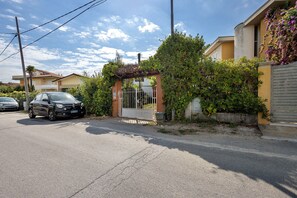 A residential street with a parked car, a gated entrance, and houses with visible balconies. - Villa "Villino Arsella" with mountain view, balcony, and air conditioning (Pietrasanta)
