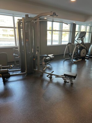 Ein Fitnessstudio mit verschiedenen Trainingsgeräten, darunter Laufband, Crosstrainer und Kraftmaschinen.