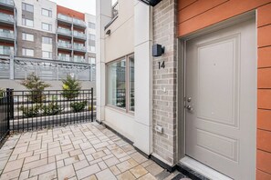 A residential building with a numbered door, a brick wall, and a metal fence. - Cozy one bed town house to explore city (Toronto)
