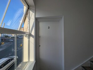 Ein Zimmer mit Blick auf eine Straße und einer Tür, die mit der Nummer 2 gekennzeichnet ist.