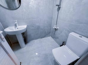 Ein Badezimmer mit Waschbecken, Toilette und Dusche.