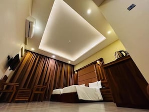 Un dormitorio moderno con cama, muebles de madera y un aplique de techo.