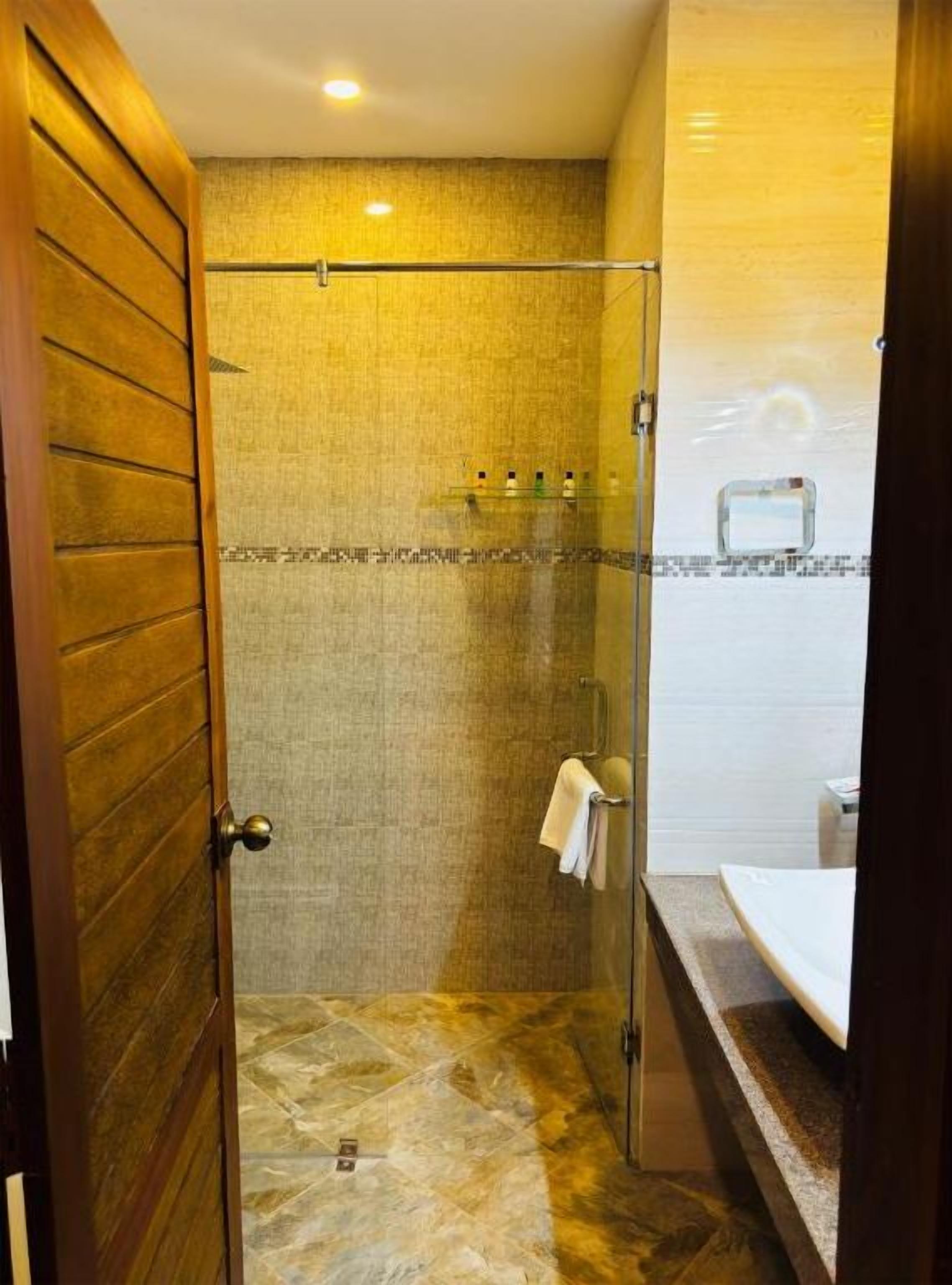 A bathroom with a shower, a towel rack, and a sink.