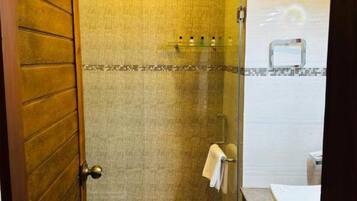 A bathroom with a shower, a towel rack, and a sink.