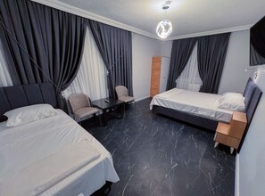 Ein Hotelzimmer mit zwei Betten, einem Schreibtisch und einem Stuhl.
