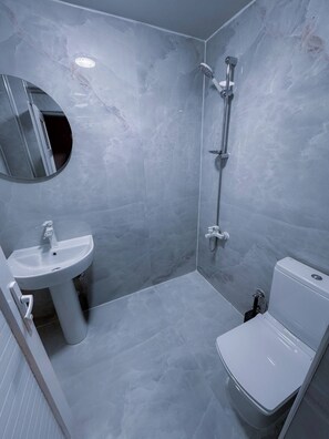 Ein Badezimmer mit Waschbecken, Toilette und Dusche.