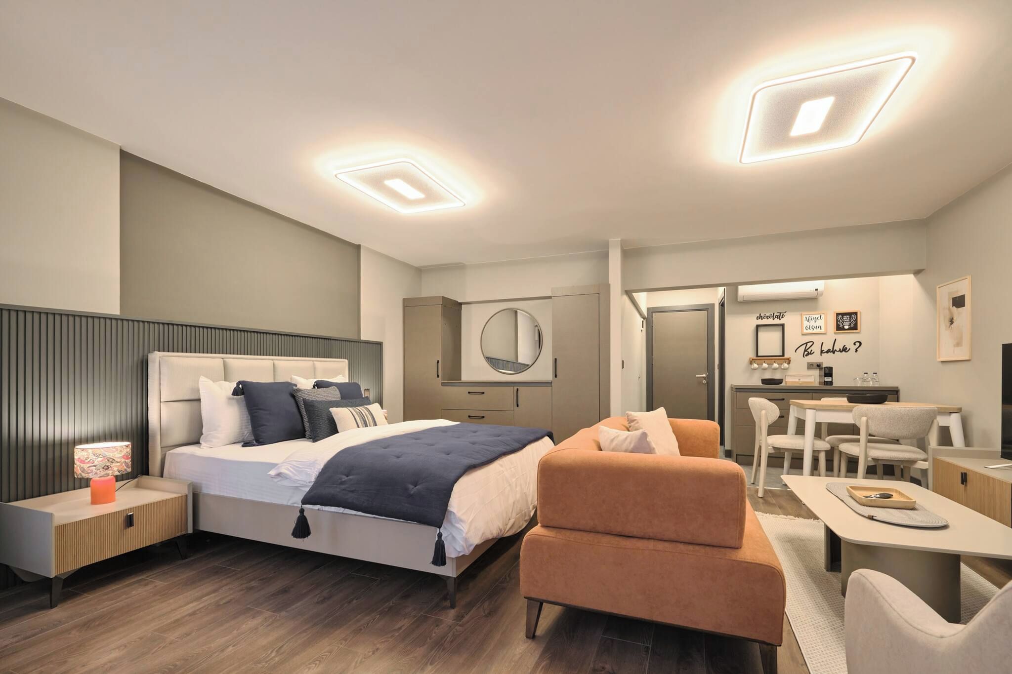 A modern bedroom with a bed, bedside table, and a desk area with a chair.