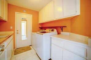 A laundry room with a washing machine, a dryer, and cabinets.