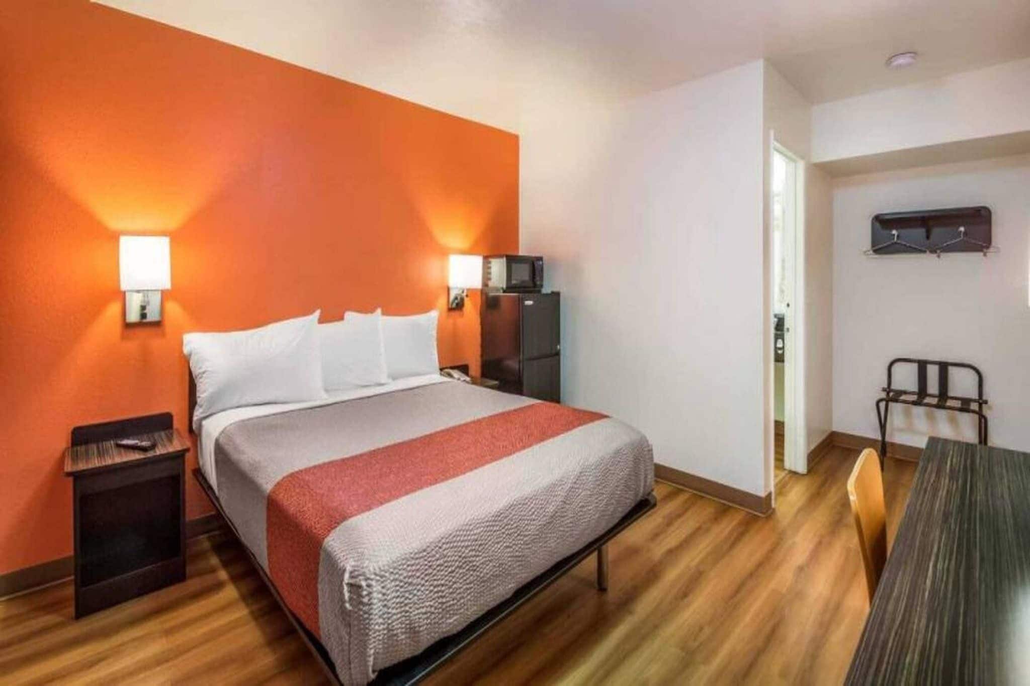 Ein Hotelzimmer mit Bett, Nachttischen, Schreibtisch und Stuhl.