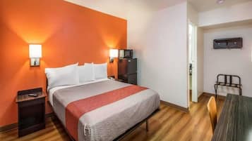 Ein Hotelzimmer mit Bett, Nachttischen, Schreibtisch und Stuhl.
