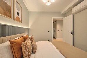 A modern bedroom with a bed, pillows, a headboard, and a door. - Nakamura, 3BR, Serene, Charming (Kadıköy)
