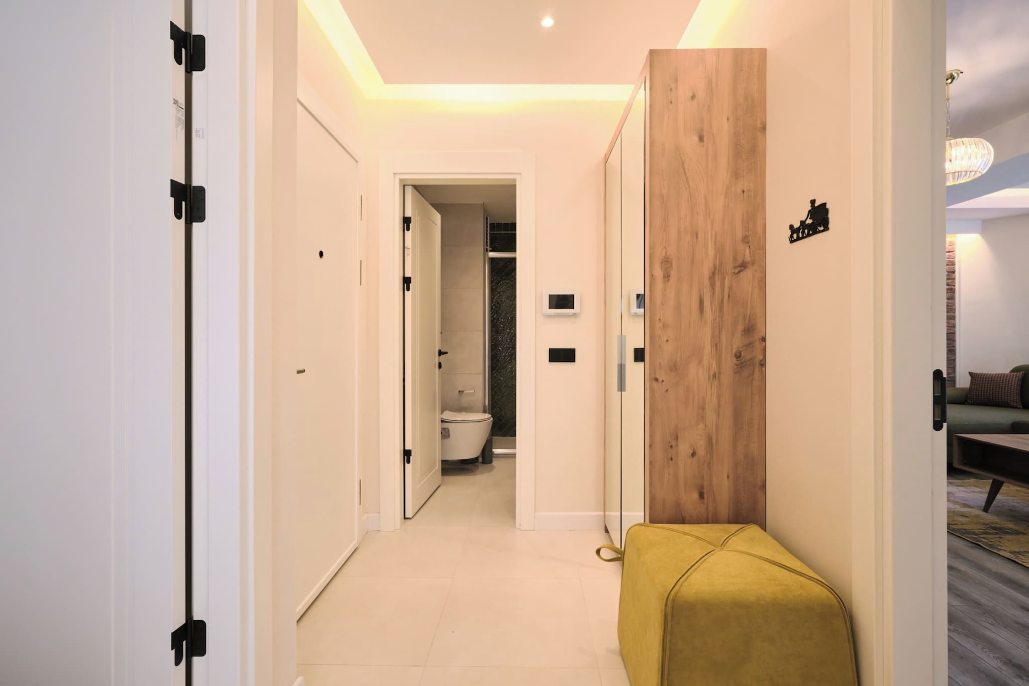 Un pasillo moderno con un revestimiento de madera, un banco y vistas al baño.