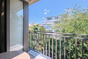 A balcony with a metal railing, overlooking a residential area with trees and buildings. - Vega, Modern 2BR, Best Loc (Kadıköy)